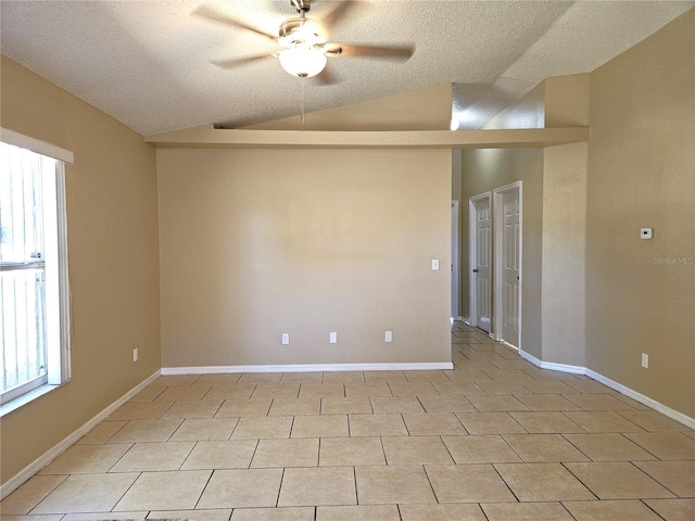 tiled spare room featuring ceiling fan, vaulted ceiling, and a textured ceiling