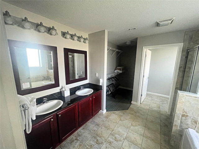 bathroom featuring vanity, separate shower and tub, and a textured ceiling