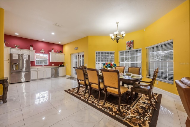 dining space featuring sink and a notable chandelier