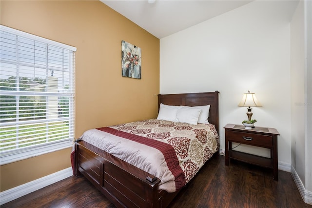 bedroom with vaulted ceiling and dark hardwood / wood-style flooring