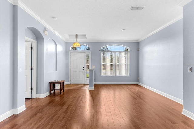 entryway with hardwood / wood-style floors and crown molding