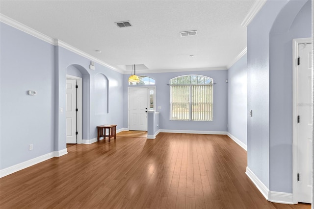 entrance foyer with hardwood / wood-style flooring, crown molding, and a textured ceiling