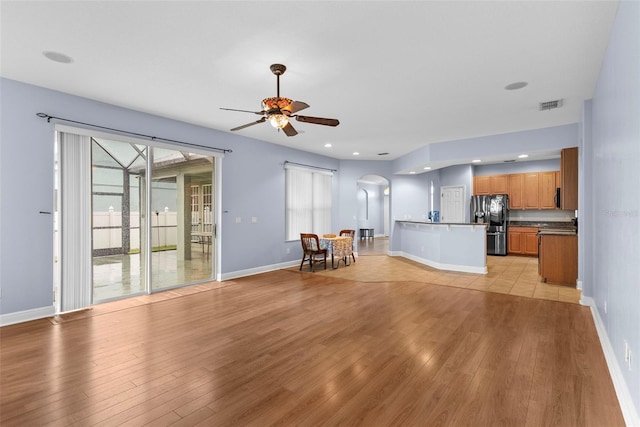 unfurnished living room featuring ceiling fan and light hardwood / wood-style flooring