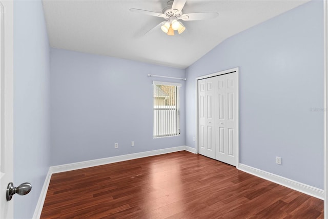 unfurnished bedroom with ceiling fan, vaulted ceiling, dark wood-type flooring, and a closet