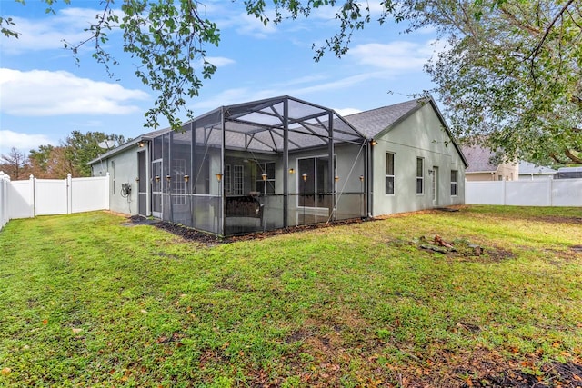 back of house with a lanai and a lawn