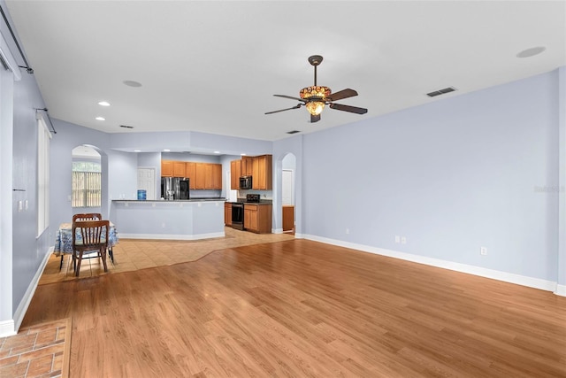 unfurnished living room featuring ceiling fan and light hardwood / wood-style floors