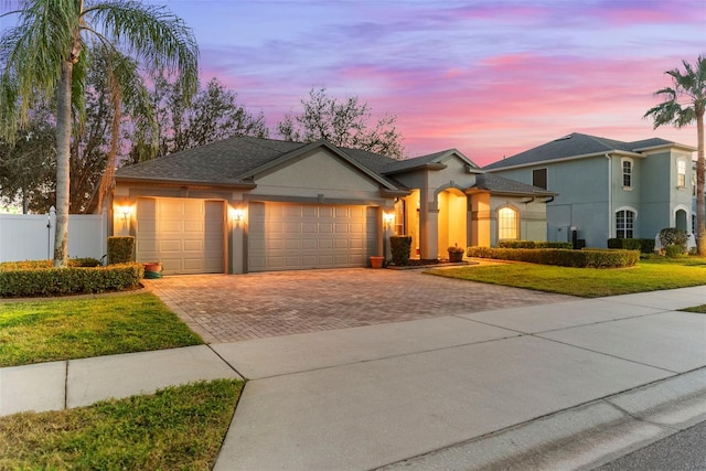 view of front of home with a garage and a lawn