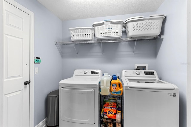 washroom featuring washing machine and dryer and a textured ceiling