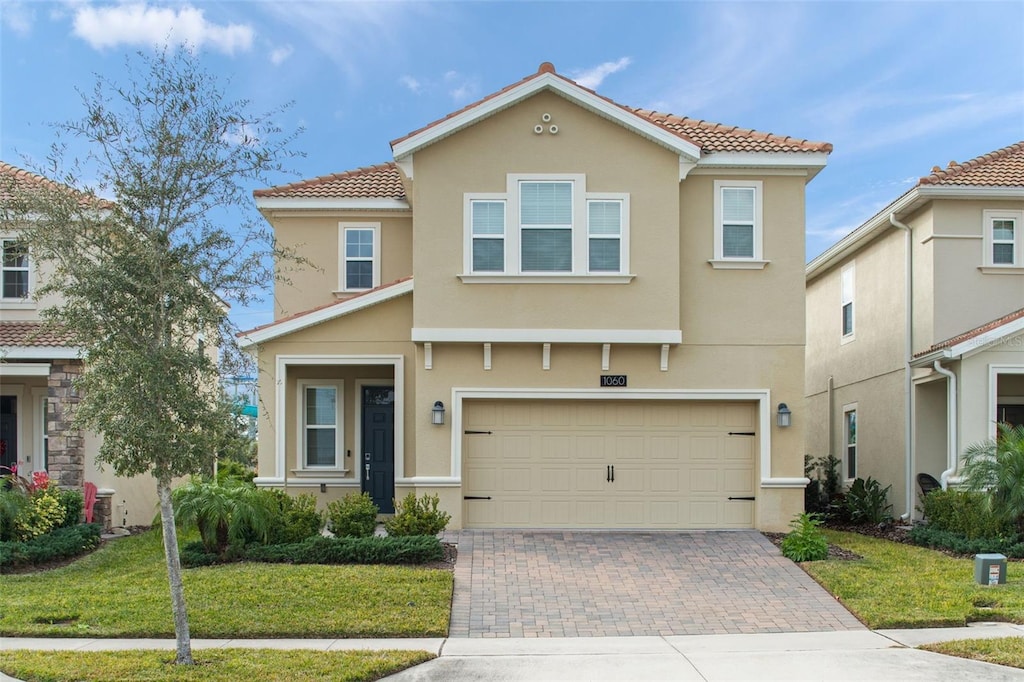 mediterranean / spanish-style home featuring a front yard and a garage