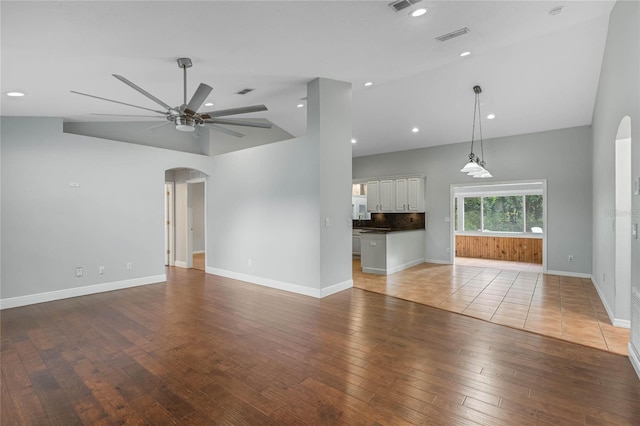 unfurnished living room featuring hardwood / wood-style flooring, lofted ceiling, and ceiling fan