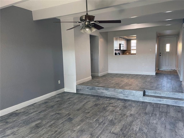 unfurnished living room featuring ceiling fan and dark hardwood / wood-style floors