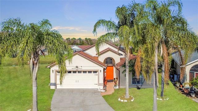 mediterranean / spanish-style home with a garage and a lawn