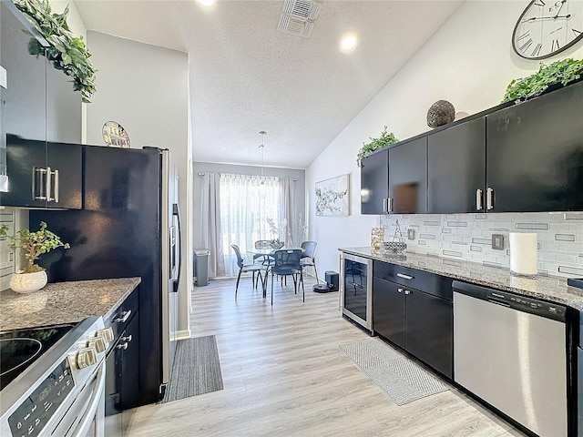 kitchen featuring decorative light fixtures, wine cooler, lofted ceiling, light hardwood / wood-style floors, and stainless steel appliances