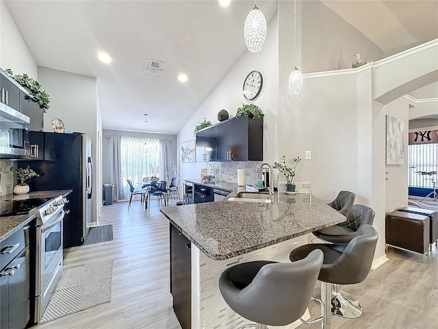 kitchen featuring decorative light fixtures, a kitchen breakfast bar, and stainless steel appliances