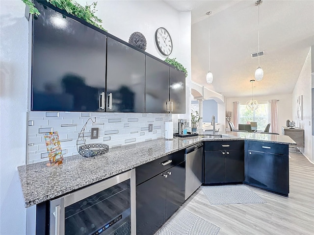 kitchen featuring beverage cooler, decorative light fixtures, sink, kitchen peninsula, and stainless steel dishwasher