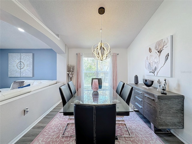 dining room featuring a textured ceiling, dark hardwood / wood-style floors, and an inviting chandelier