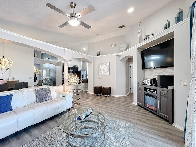 living room featuring ceiling fan, hardwood / wood-style floors, and ornate columns