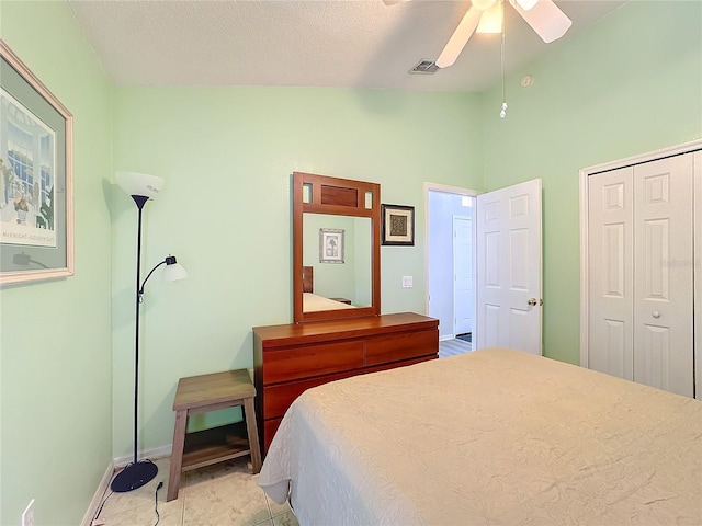 tiled bedroom with ceiling fan, a closet, and a textured ceiling