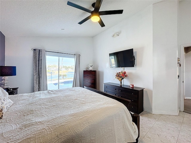 bedroom featuring ceiling fan, vaulted ceiling, access to exterior, light tile patterned flooring, and a textured ceiling