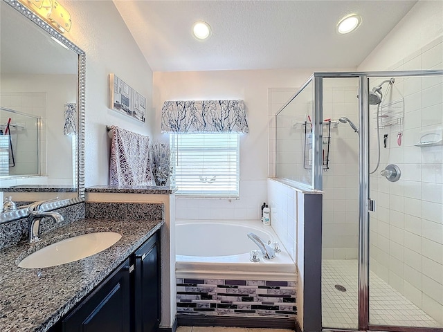 bathroom with plus walk in shower, vaulted ceiling, and vanity