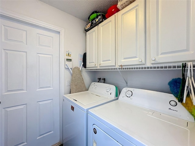 clothes washing area featuring cabinets, a textured ceiling, and independent washer and dryer