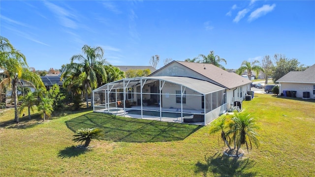 back of house with a lanai, a lawn, and a patio