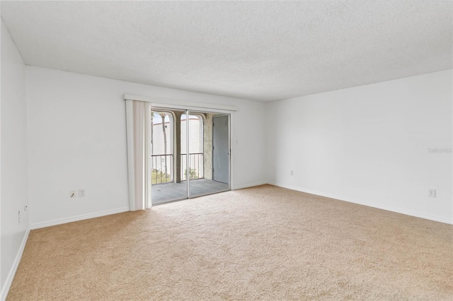 carpeted empty room with a textured ceiling