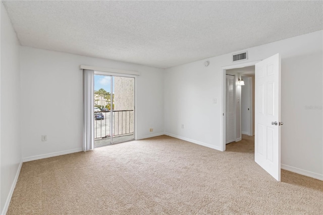 carpeted spare room featuring a textured ceiling