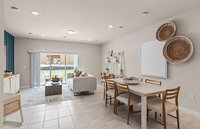 tiled dining area with a textured ceiling