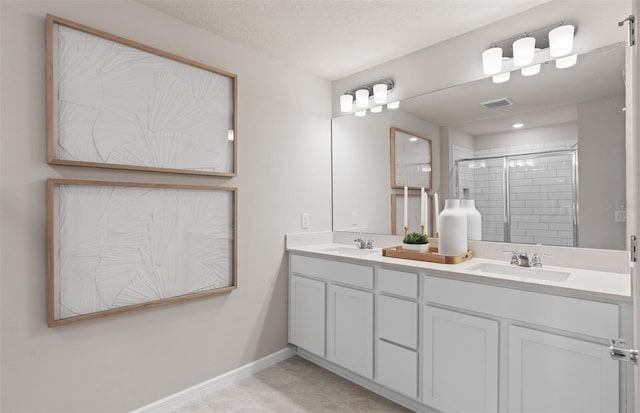 bathroom with a textured ceiling, walk in shower, and vanity