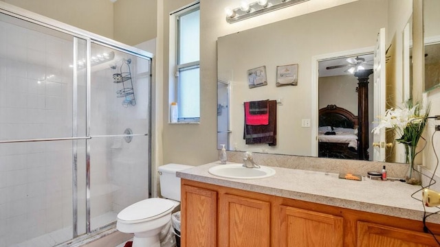 bathroom with toilet, ceiling fan, an enclosed shower, and vanity