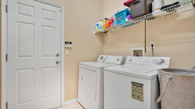 laundry area with separate washer and dryer and light tile patterned floors