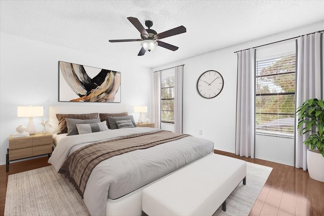 bedroom with multiple windows, hardwood / wood-style floors, and a textured ceiling