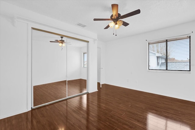 unfurnished bedroom with hardwood / wood-style flooring, ceiling fan, a textured ceiling, and a closet