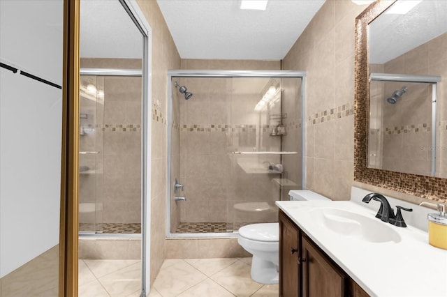 bathroom with vanity, a shower with door, and toilet