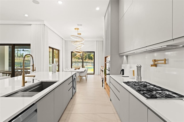 kitchen with decorative light fixtures, sink, gray cabinetry, and stainless steel appliances