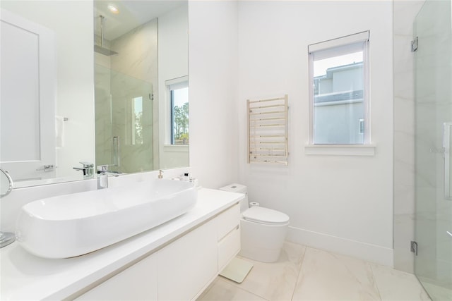 bathroom with toilet, vanity, and a shower with shower door