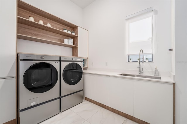 washroom featuring cabinets, washing machine and clothes dryer, and sink