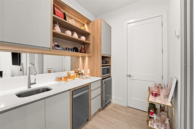 kitchen with sink, light hardwood / wood-style flooring, stainless steel appliances, and wine cooler