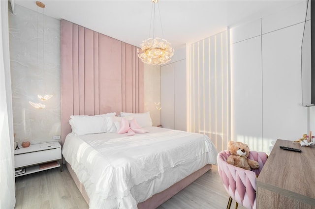 bedroom with a chandelier and light hardwood / wood-style flooring