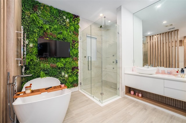 bathroom featuring hardwood / wood-style flooring, vanity, and separate shower and tub