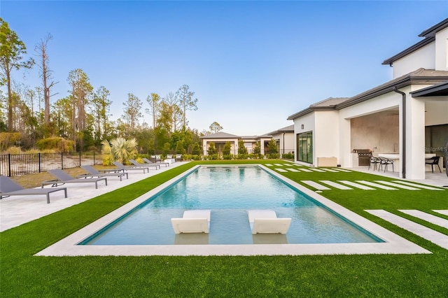 view of pool with ceiling fan, a lawn, and a patio