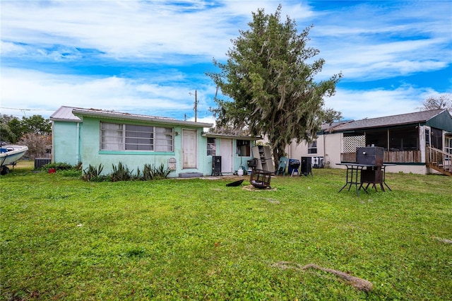 view of front of home with central AC unit and a front lawn