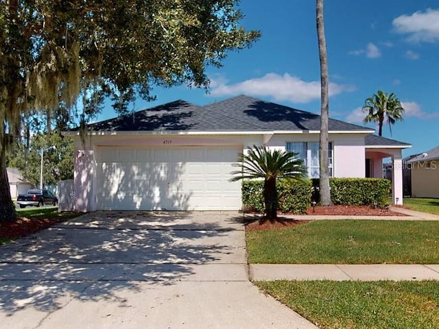 ranch-style house featuring a front lawn and a garage