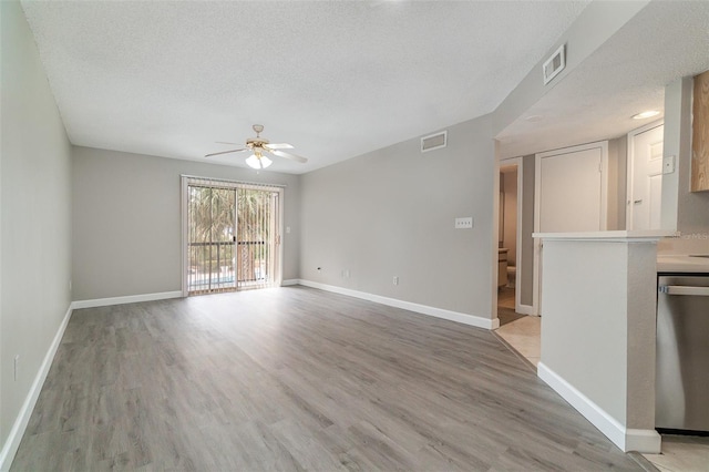 unfurnished living room with ceiling fan, light hardwood / wood-style floors, and a textured ceiling