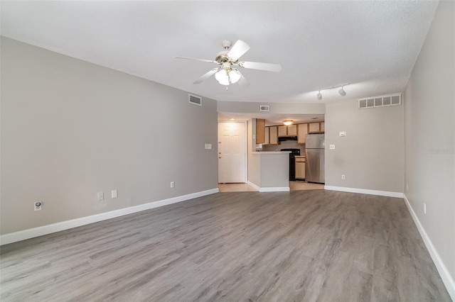 unfurnished living room with a textured ceiling, light hardwood / wood-style flooring, and ceiling fan