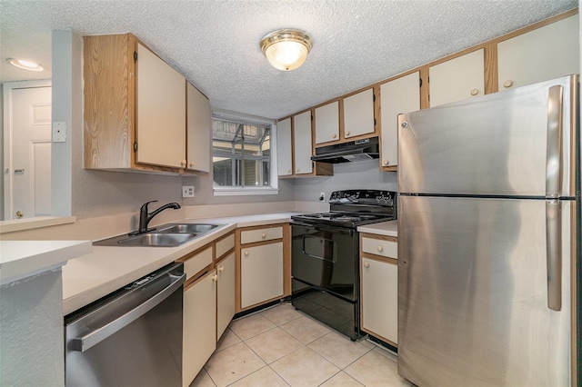 kitchen featuring light tile patterned flooring, stainless steel appliances, sink, and a textured ceiling