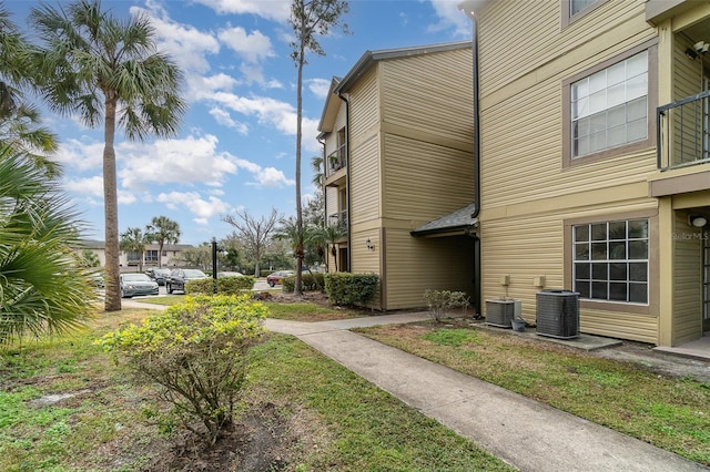 exterior space featuring cooling unit and a lawn