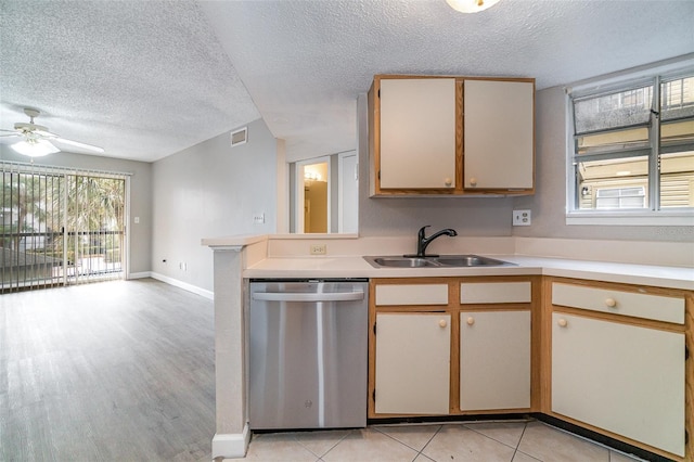 kitchen with sink, dishwasher, ceiling fan, a textured ceiling, and kitchen peninsula