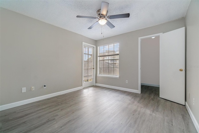 empty room with ceiling fan, a textured ceiling, and light hardwood / wood-style floors